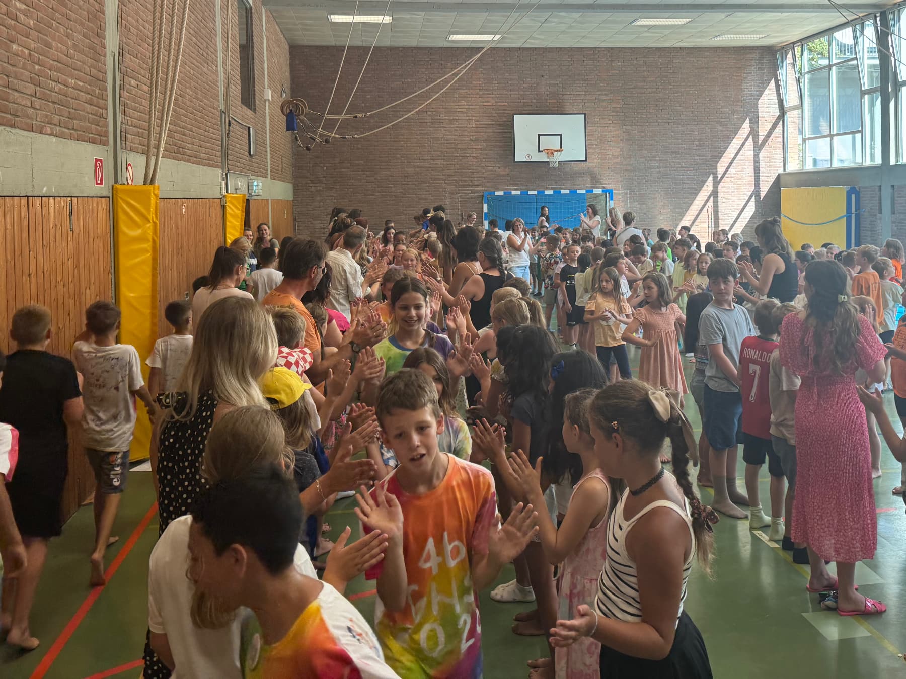 Viertklässler laufen durch den Spalier der 1. bis 3. Klassen aus der Halle